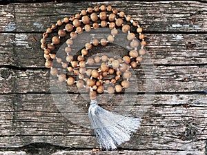 Rosary beads on the wooden background. Rudraksha Mala for Mantras. 108 beads. photo