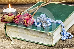 Rosary, bible, rose on the table