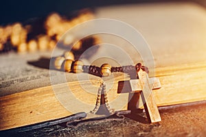 Rosary with cross laying on a Bible book photo