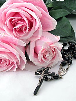 Rosary cross and pink roses