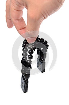 Rosary in hand on a white background isolated