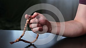 A rosary in a man`s hand. Calm, meditation, communion with God