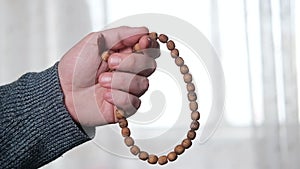 Rosary in a man`s hand close-up. Prayer, meditation concept