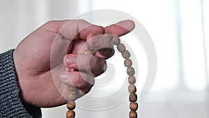 Rosary in a man`s hand close-up. Prayer, meditation concept