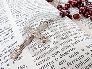 Rosary over an old holy bible written in Portuguese.