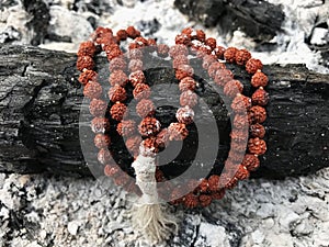 Rosary prayer beads on the ash cinder background. Rudraksha. Mala. Mantra. 108 beads.