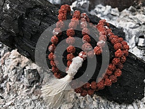 Rosary prayer beads on the ash cinder background. Rudraksha. Mala. Mantra. 108 beads.