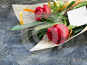Rosas rojas con una espiga y una tarjeta de regalo, para regalo de dÃÂ­a de San ValentÃÂ­n o de San Jorge photo