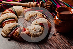 Rosca de reyes or Epiphany cake and clay mug of mexican hot chocolate on a wooden table in Mexico Latin America photo