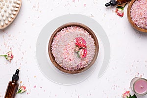 Rose bath salt with flowers and natural oil bottles on white background