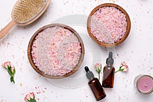 Rose bath salt and natural oil bottles on white background