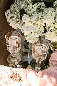 Rose blush wine in glasses. Bottle of rose wine with flowers on background. Prosecco