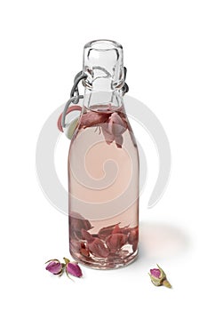 Rose bud water in a glass bottle on white background