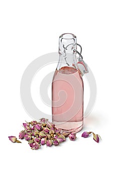 Rose bud water in a glass bottle on white background