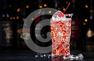 Rose with cherry, alcoholic cocktail drink with pink vermouth, amaretto liqueur, cherry juice, red cocktail cherry and ice, black