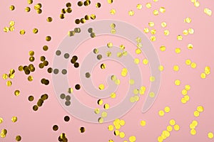 Rose color pastel festive background with golden holographic confetti. Flat lay style with copy space for text, design.