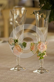Rose decorated wedding glasses on banket table.