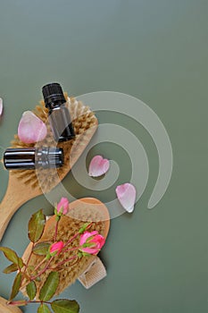 Rose essential oil .Aromatherapy and cosmetics. Glass bottles, flowers on green background.Organic natural rose oil