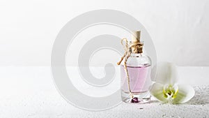 Rose essential oil in glass bottle and orchid flower