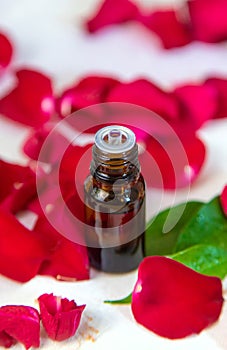 Rose essential oil in a small bottle. Selective focus.