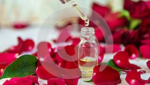 Rose essential oil in a small bottle. Selective focus.