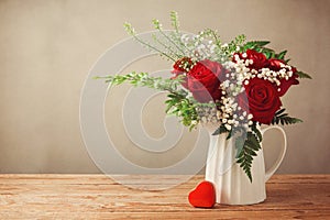 Rose flower bouquet and heart shape box on wooden table with copy space