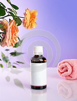 Rose flowers with aromatherapy essential rose oil in a glass bottle over very peri background. wellbeing concept