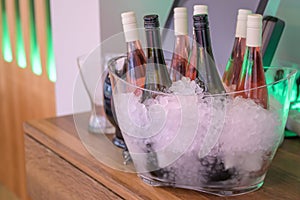 Rose flowers ice cooled sparkling wine and champagne bottle in bucket on a party unlabeled textspace