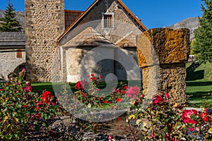 Rose garden near church on the french mountain city. Countryside landscape near a famous french resort Auron, Europe