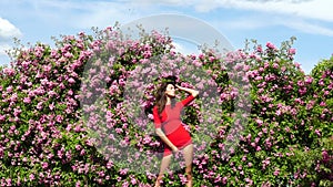 Rose garden. Spring woman in flower park. Girl with roses bush. Summer nature.