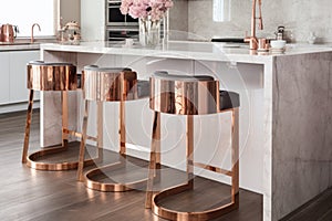 rose-gold bar stools by a marble kitchen island