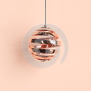 Rose-gold Christmas ornament on pastel background