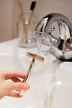 Rose-gold safety shaving razor in the hand