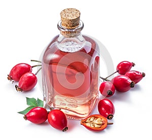 Rose-hips and rosehip seed oil on the white background