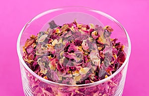 Rose petals in a glass bowl over pink