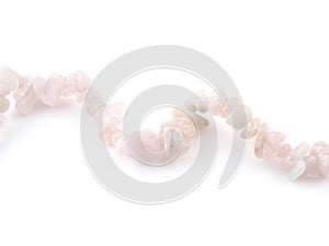 Rose quartz, beads pink stone in front of white background