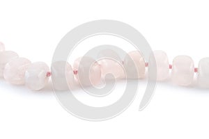 Rose quartz, beads pink stone in front of white background