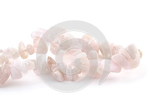 Rose quartz, beads pink stone in front of white background