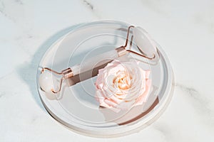 Rose quartz face roller on marble background, top view. mockup with facial massage tool. Skin care, body treatment and