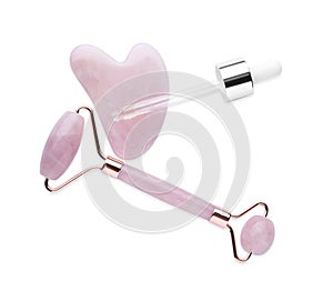 Rose quartz gua sha tool, facial roller and dropper isolated on white, top view