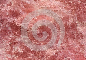 Rose quartz texture - closeup of a rough rose quartz stone surface structure for backgrounds