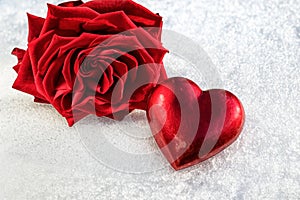 Rose and Red Heart on ice wet snow, selective focus