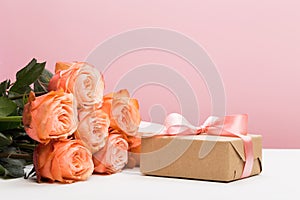 Rose roses with present on pink background, mother`s day, woman`s day