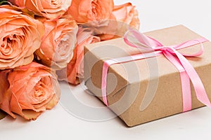 Rose roses with present on pink background, mother`s day, woman`s day