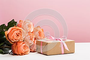 Rose roses with present on pink background, mother`s day, woman`s day