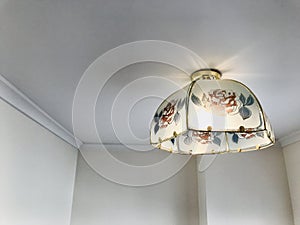 A rose-shaped carved petal-shaped lamp on the ceiling.