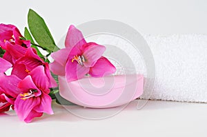 Rose soap, towel and flowers on white background