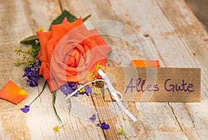 Rose with and tag with german text, Alles Gute, means all the best