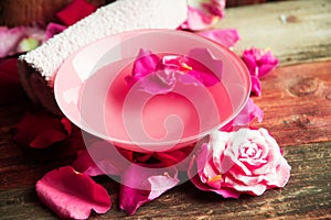 Spa setting with rose pink flowers and petals,bath salt and body