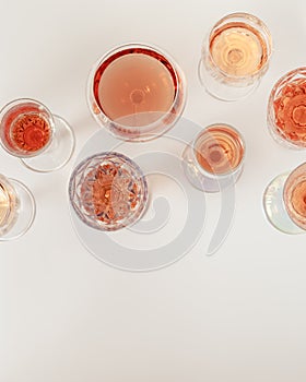 Rose wine assortment in crystal glasses, rose champagne sparkling wine on light background. Summer alcoholic drink